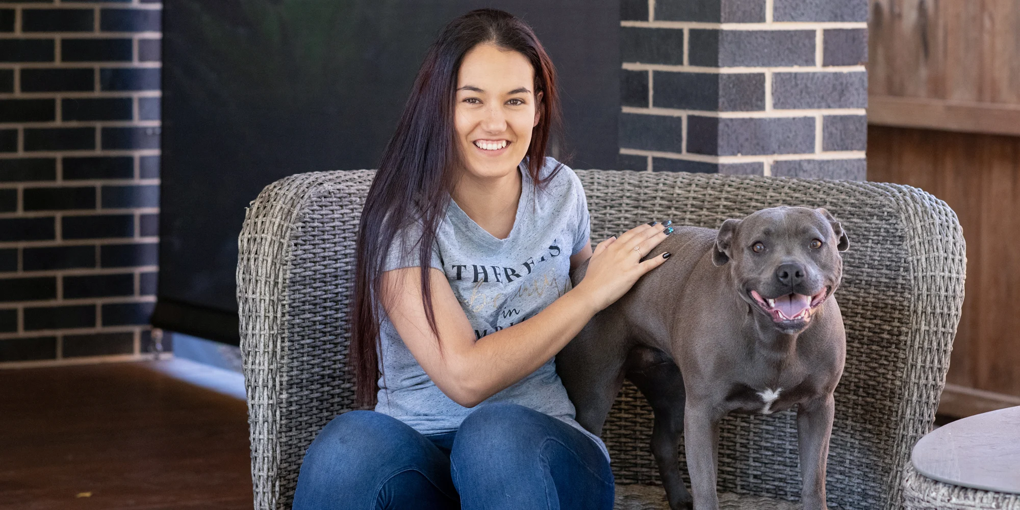 Open Universities Australia student Taylah sitting with her English staffy dog.