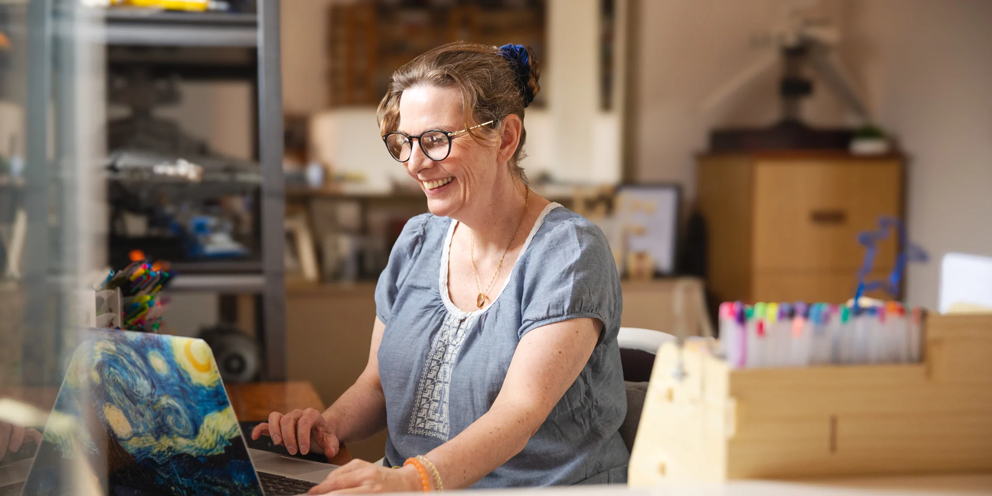 Open Universities Australia student, Wendy, sitting at a workstation with a laptop computer.