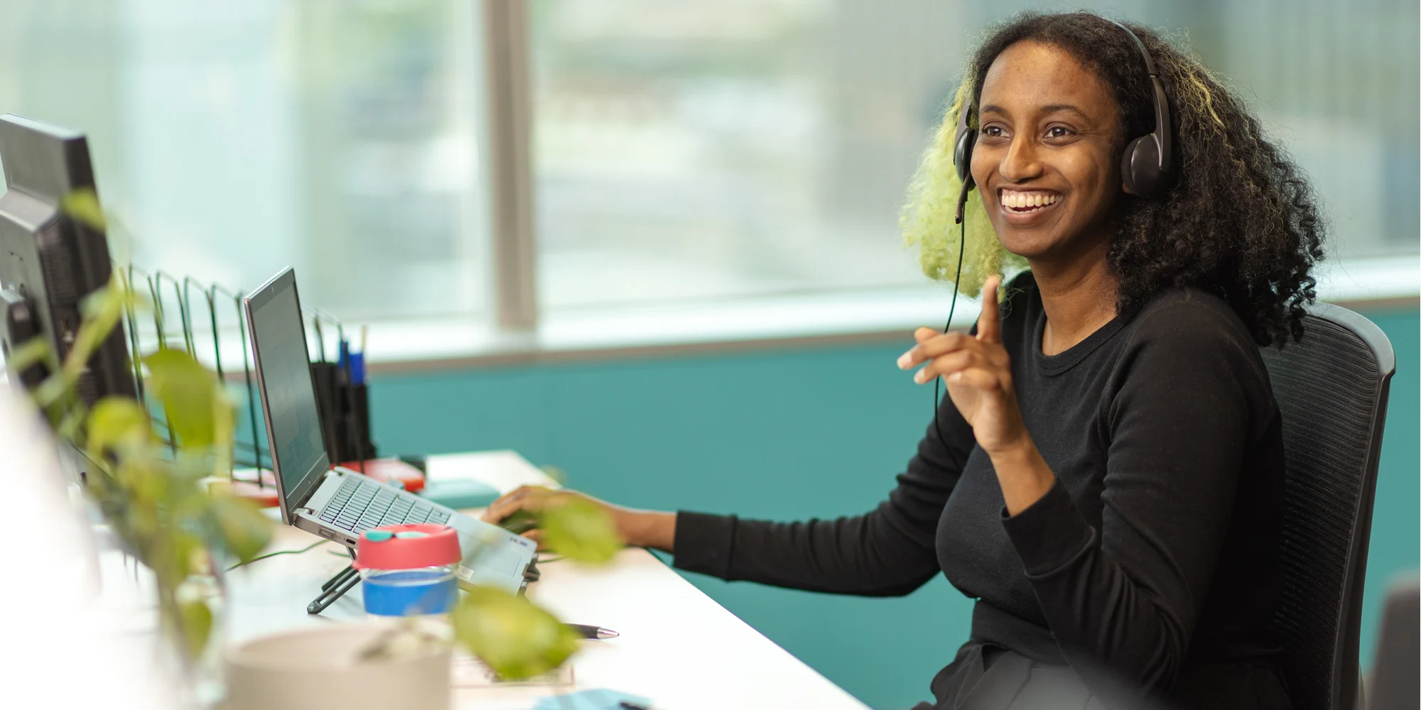Nabila Jamal smiling at her desk at the Open Universities Australia office