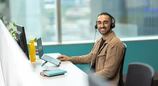 Open Universities Australia student advisor, Josh, seated at a workstation.