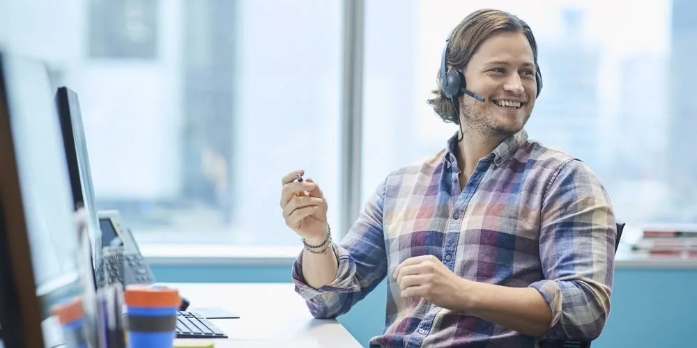 Smiling Open Universities Australia staff taking a call using a headset