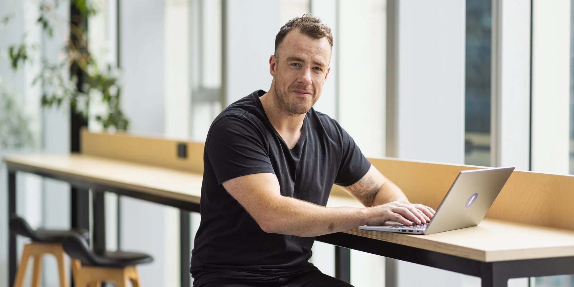 Student advisor working on a laptop in OUA’s bright and modern office atrium