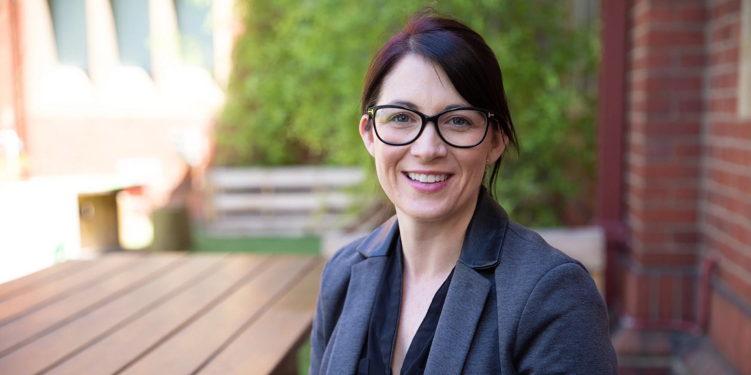 Postgraduate student Melissa smiling and relaxing outside.