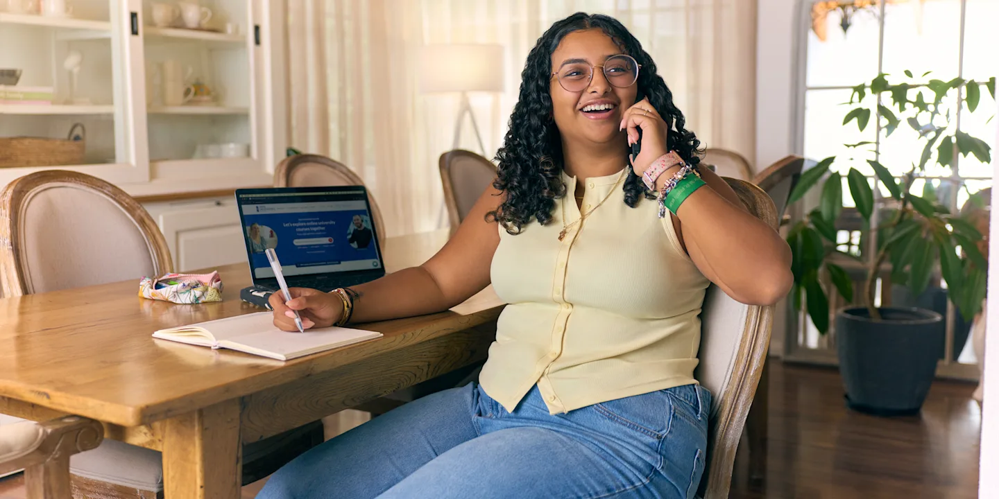 Smiling student using a laptop at home