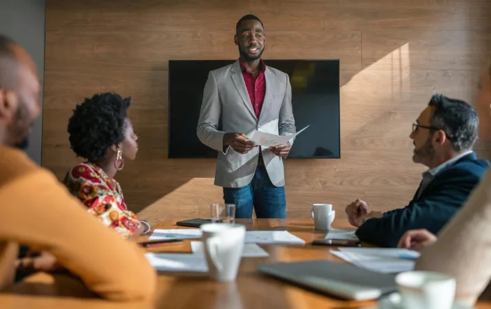 Man smiling as he presents a research report