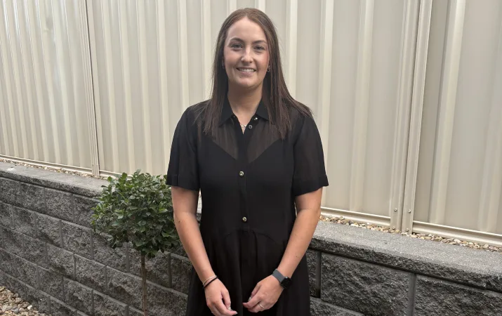 Teacher Amy Renshaw posing happily in a garden