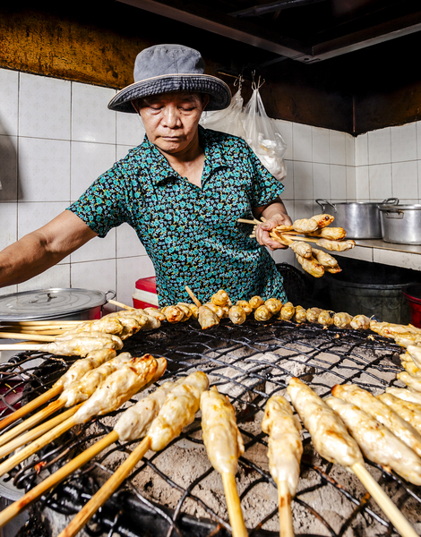 The charcoal grill burns under meat skewers