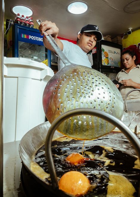 Fresh buñuelos sizzling away until perfectly crisp and golden.