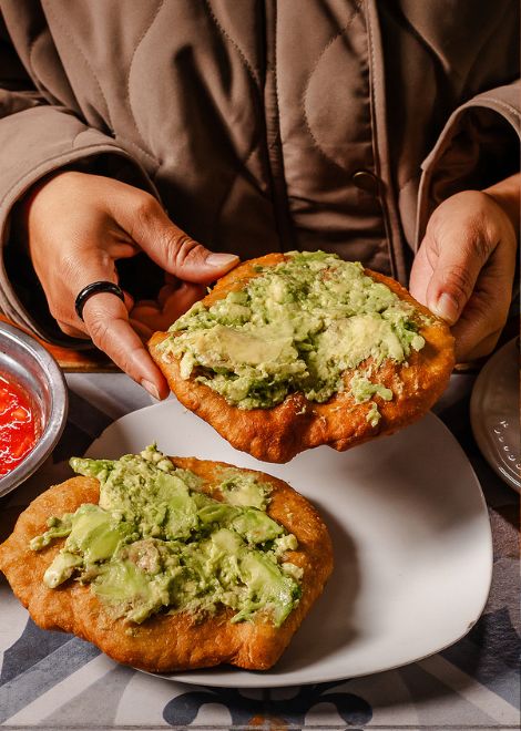 Golden sopaipillas topped with creamy avocado, a simple combination beloved throughout Chile