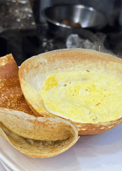 Crisp egg hoppers made from fermented rice flour and coconut milk.