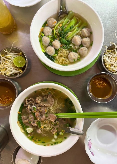 A steaming bowl of mee kieo teuk with fish and bouncy fishballs.