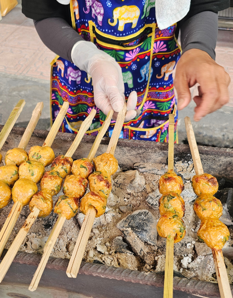 Jaeng-lon fish cake skewers grilling over charcoal