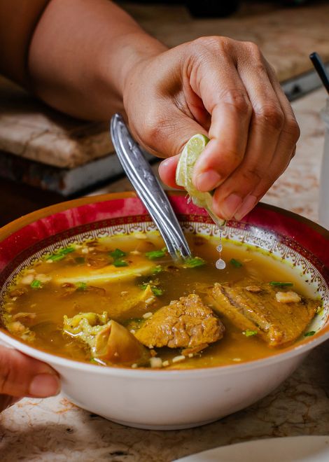 A steaming bowl of soto Madura, rich with tender beef and fragrant spices.