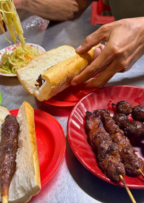 Smoky beef and sausage skewers with crusty baguette and tangy pickled papaya.