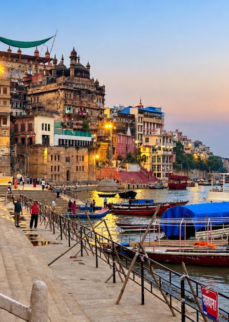 Palaces and temples line the riverbank at dusk.