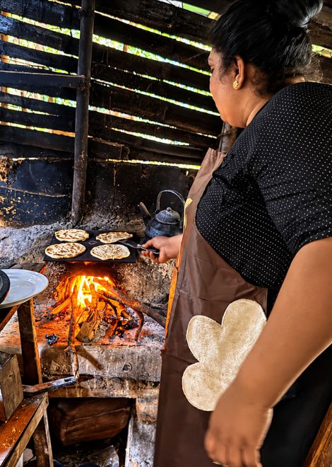 The smoky aroma of coconut roti cooking over a wood fire.