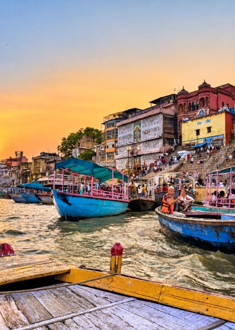 Hop aboard a wooden boat as the sun sets over the Ganges.