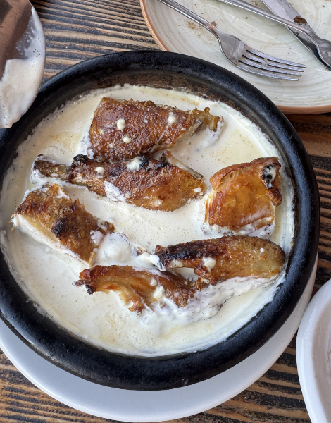 Fried chicken in a rich garlic sauce, known as shkmeruli