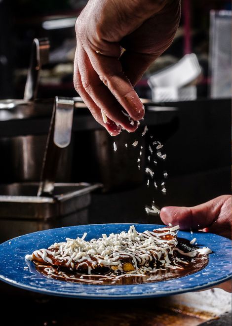 Enmolada de plátano, plantain-filled tortilla bathed in complex mole sauce