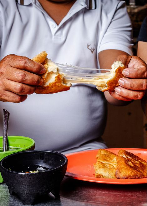 Freshly fried Mexican empanadas stuffed with cheese and topped with kastikan fried pork 