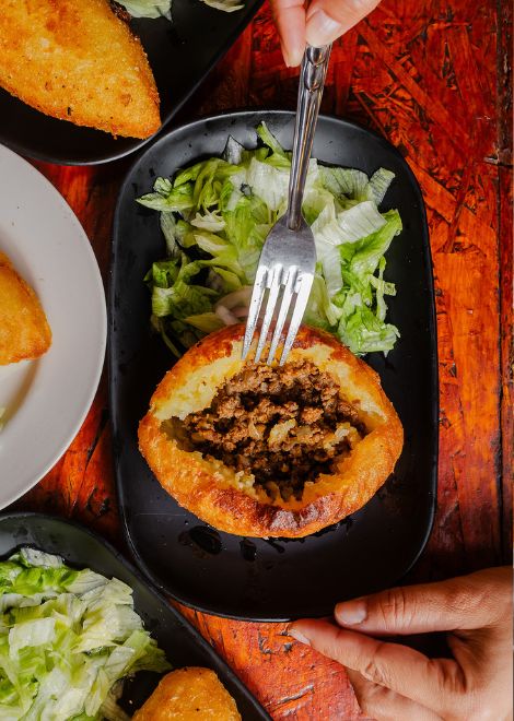Crispy papa rellena served with fresh sarsa criolla.