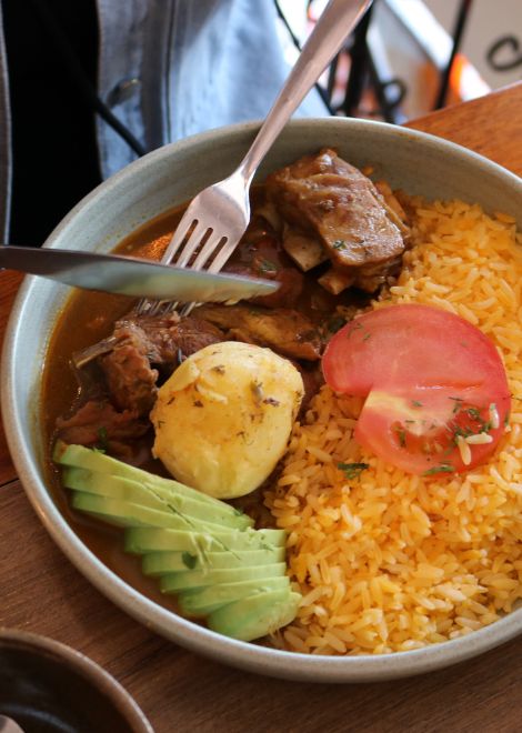 Rich seco de chivo Ecuadorian goat stew with avocado