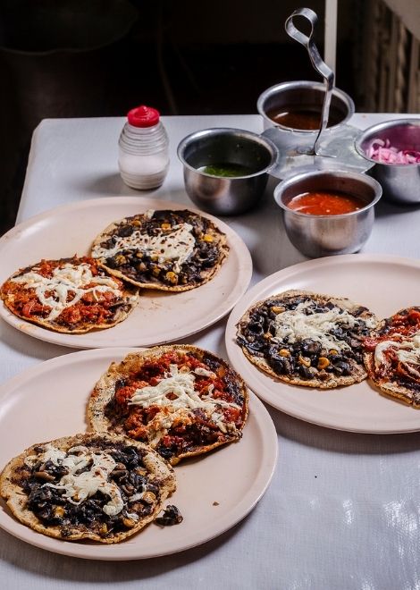 Corn masa memela with pressed pork cracklings and huitlacoche