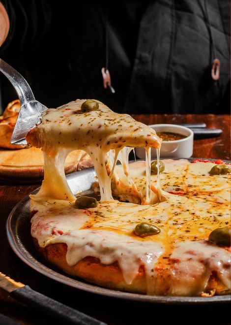 A hallmark of Argentine pizza culture, a thick crust buried beneath a blanket of bubbling cheese