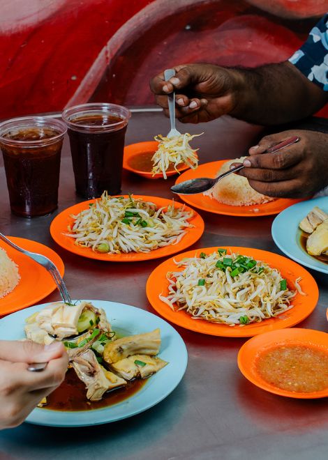 A classic Ipoh feast of Hainanese chicken, crunchy tauge, acar and oil rice.