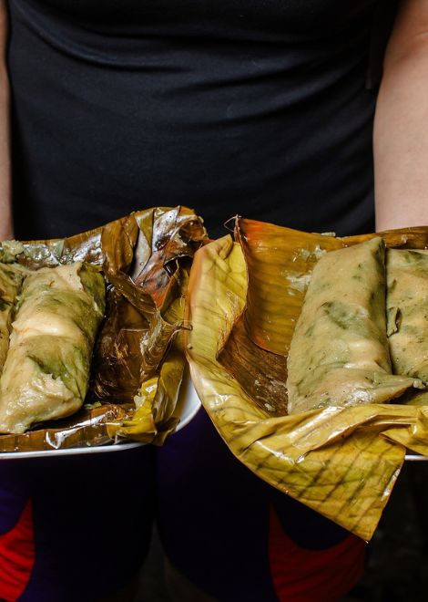 Peel back the leaves to reveal a steaming chipilín and cheese tamal.