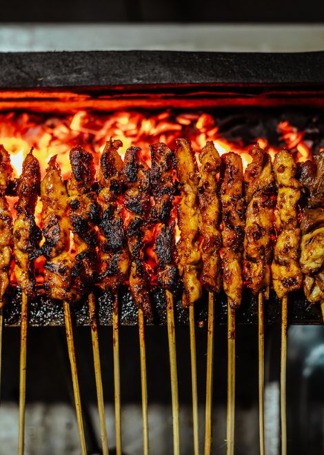 Sizzling sate kambing, tender goat skewers grilled over glowing charcoal.