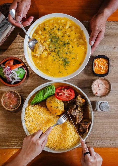 Deeply flavoured goat stew alongside a warming bowl of yahuarlocro.
