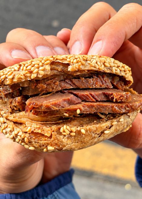 Braised beef stuffed into a crisp sesame shaobing.