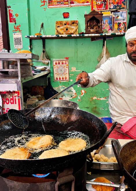 Golden kachoris puffing up in a sizzling kadai.
