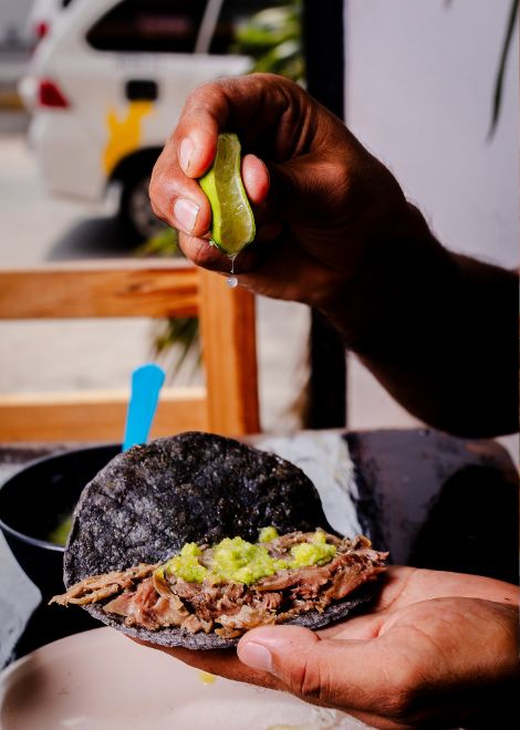 Black taco with lamb barbacoa with lime and avocado