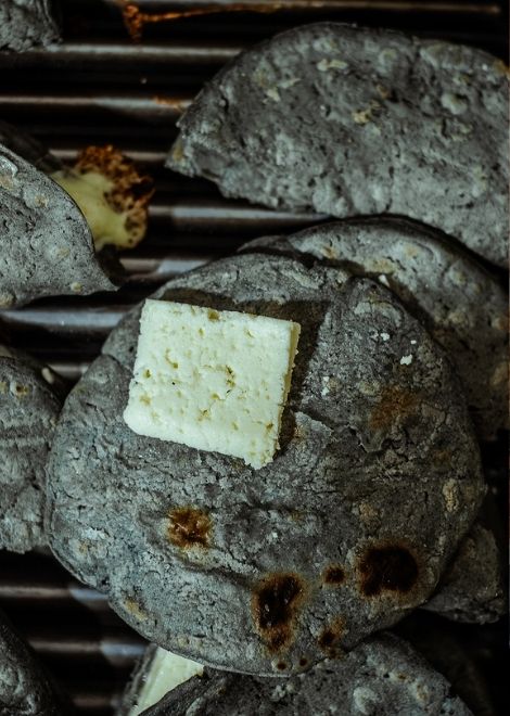 Fresh blue corn tortillas turning golden on the comal.