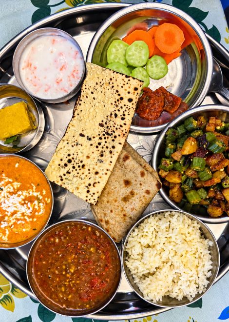 A gleaming Banarasi thali loaded with seasonal curries, daal and buttery roti.
