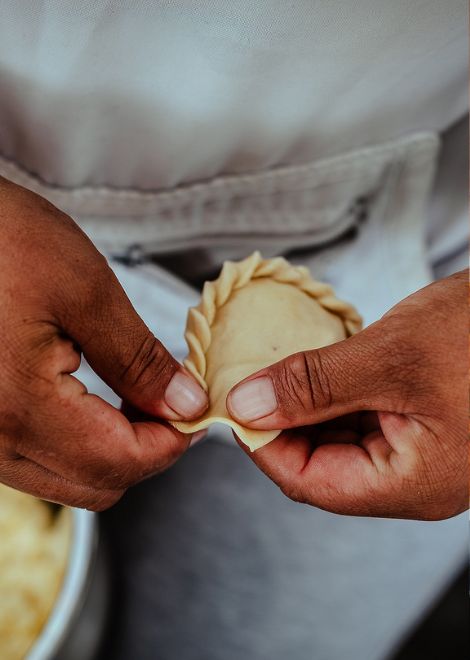 Hand-crimping fresh empanadas the traditional way.
