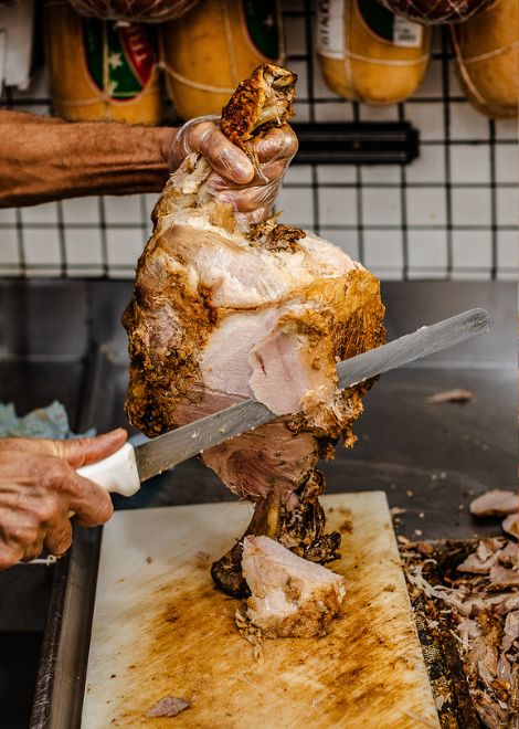 Carving slow-cooked lechón pork