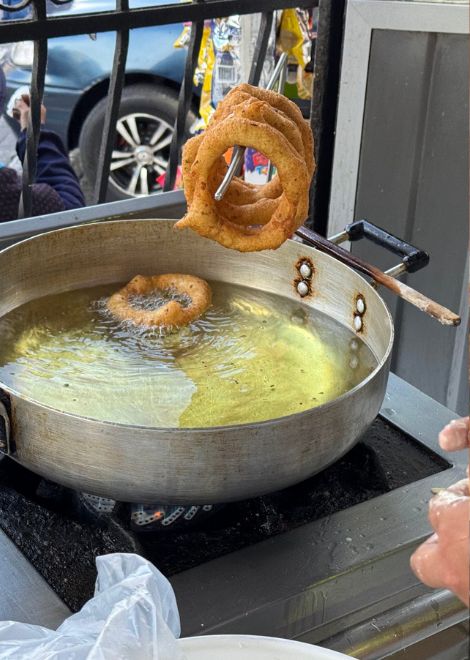 Giant buñuelos fried fresh and dripping with syrup