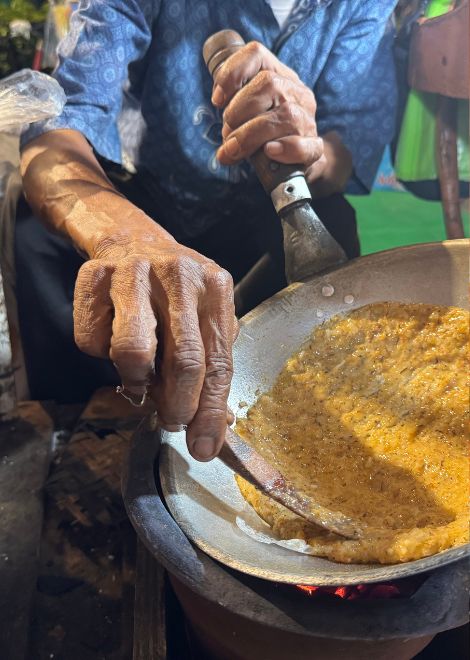 Watch kerak telor cooked over glowing charcoal.