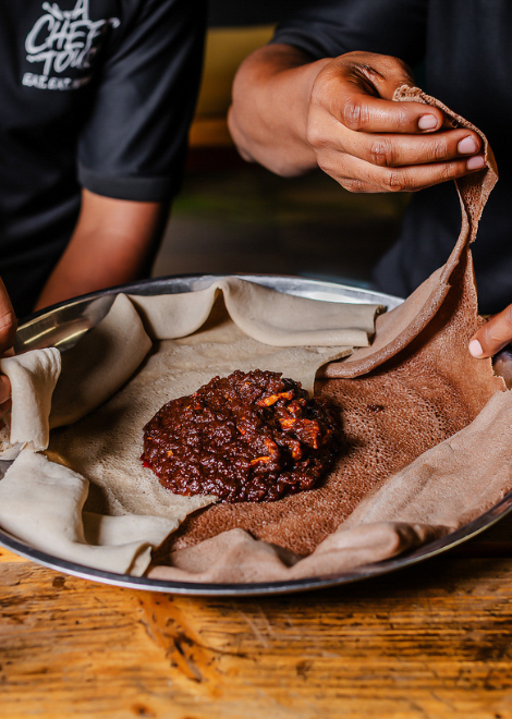 Duba quanta, dried and spiced squash stew with tangy injera