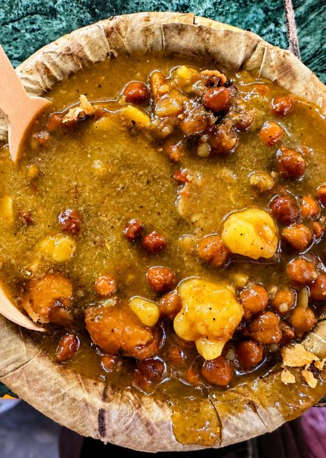 Flaky kachori broken into rich chickpea ghughni.