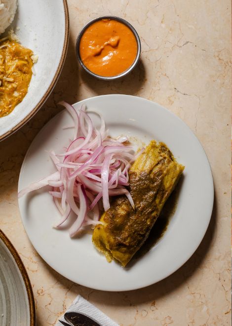 Fragrant tamal verde served with fresh sarsa criolla.