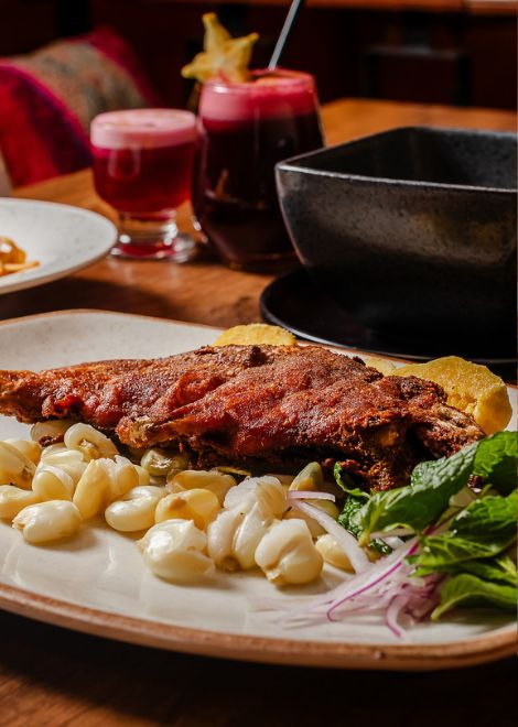 Roasted cuy served alongside hearty Andean corn soup