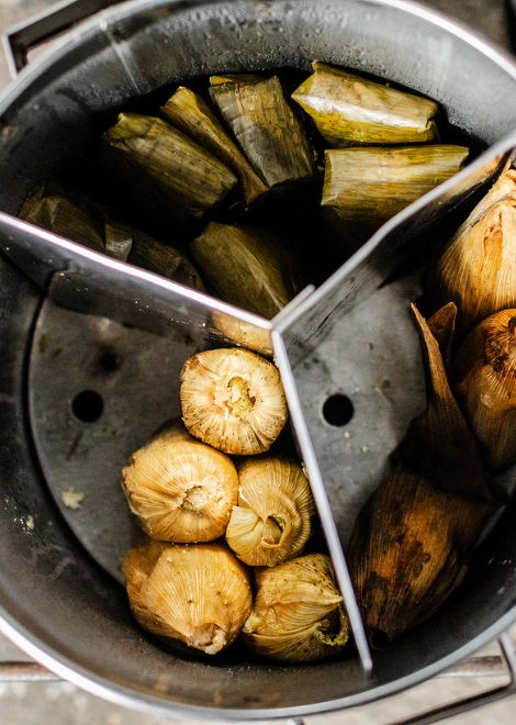 Freshly-steamed tamales encased in corn husks