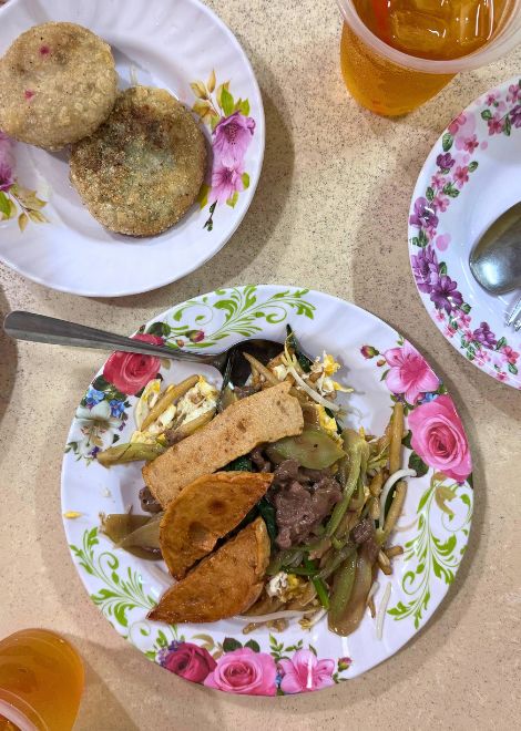Wok-fired lort chha with beef and pâté alongside golden num kachay.