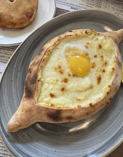 Boat-shaped khachapuri bread, drowning in cheese