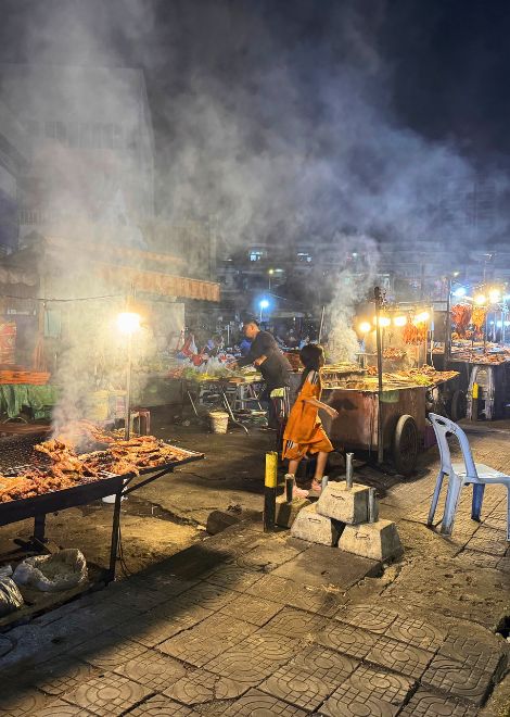 Smoke rises as dinner hits the coals on the streets of Phnom Penh.