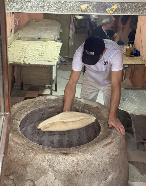 Slapping dough onto a traditional Tone clay oven